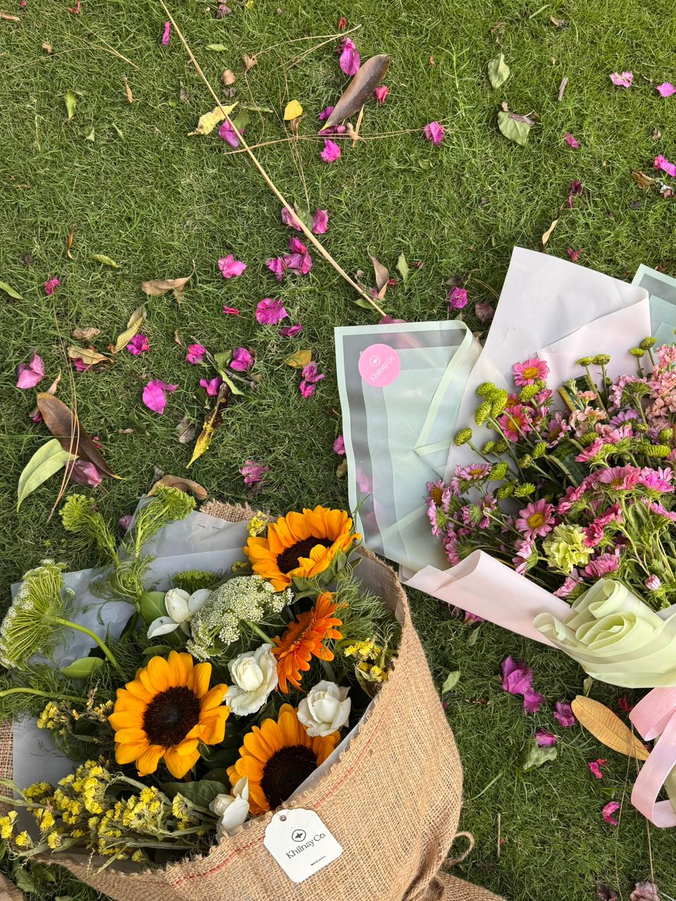 Hand-tied seasonal bouquets by Khilnay Co. laid on grass
